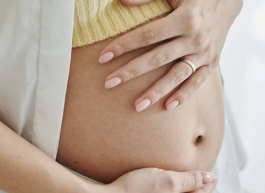 Femme enceinte se caressant le ventre